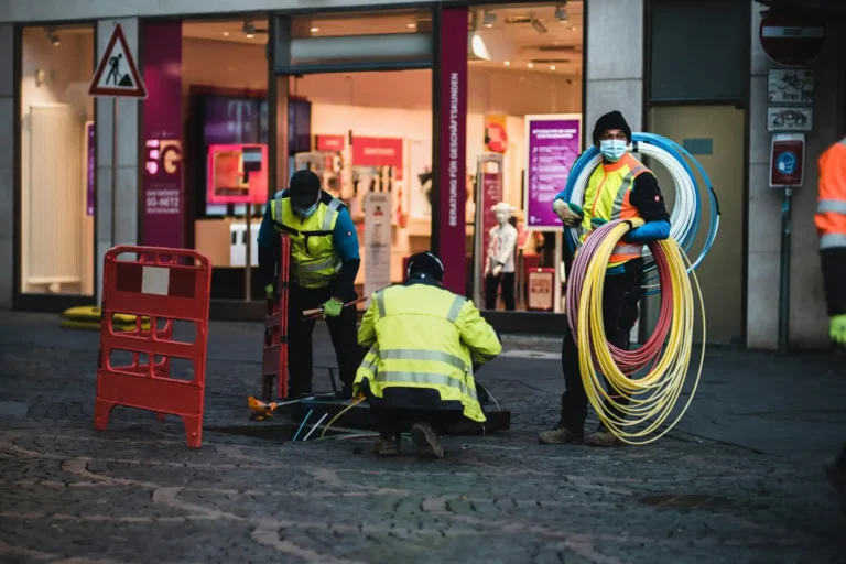 Technicians installing network cabling in a pit in the street
