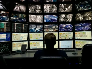 Security officer monitoring a bank of CCTV monitors